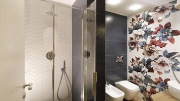 A modern bathroom with a glass-enclosed shower, a bidet, and a wooden vanity.