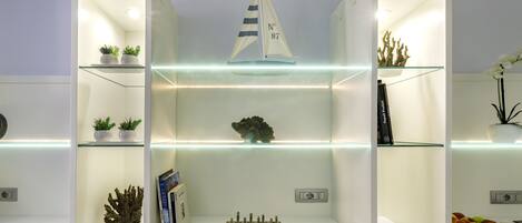 A well-organized display cabinet with shelves containing plants, a chess set, and decorative items.