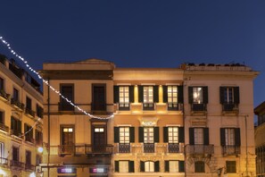 A hotel with a classic facade, multiple balconies, and a sign indicating it is a hotel. - Hotel Baylle  (Cagliari)