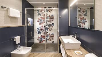 Une salle de bain moderne dotée d’une douche à paroi de verre, d’un meuble-lavabo à deux vasques et d’un grand miroir.