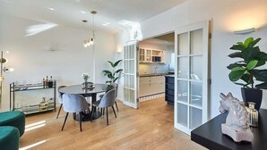 Una cucina moderna con mobili bianchi, un piano di lavoro nero e un'ampia finestra.