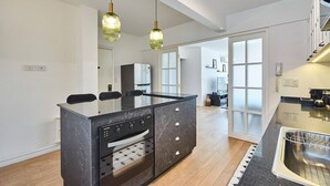 Una cucina moderna con isola centrale, forno integrato e zona pranzo con sedie.