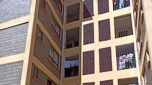 A multi-story building with a central entrance, a staircase leading to the entrance, and balconies with railings. - Honey Dew Stays (Athi River)