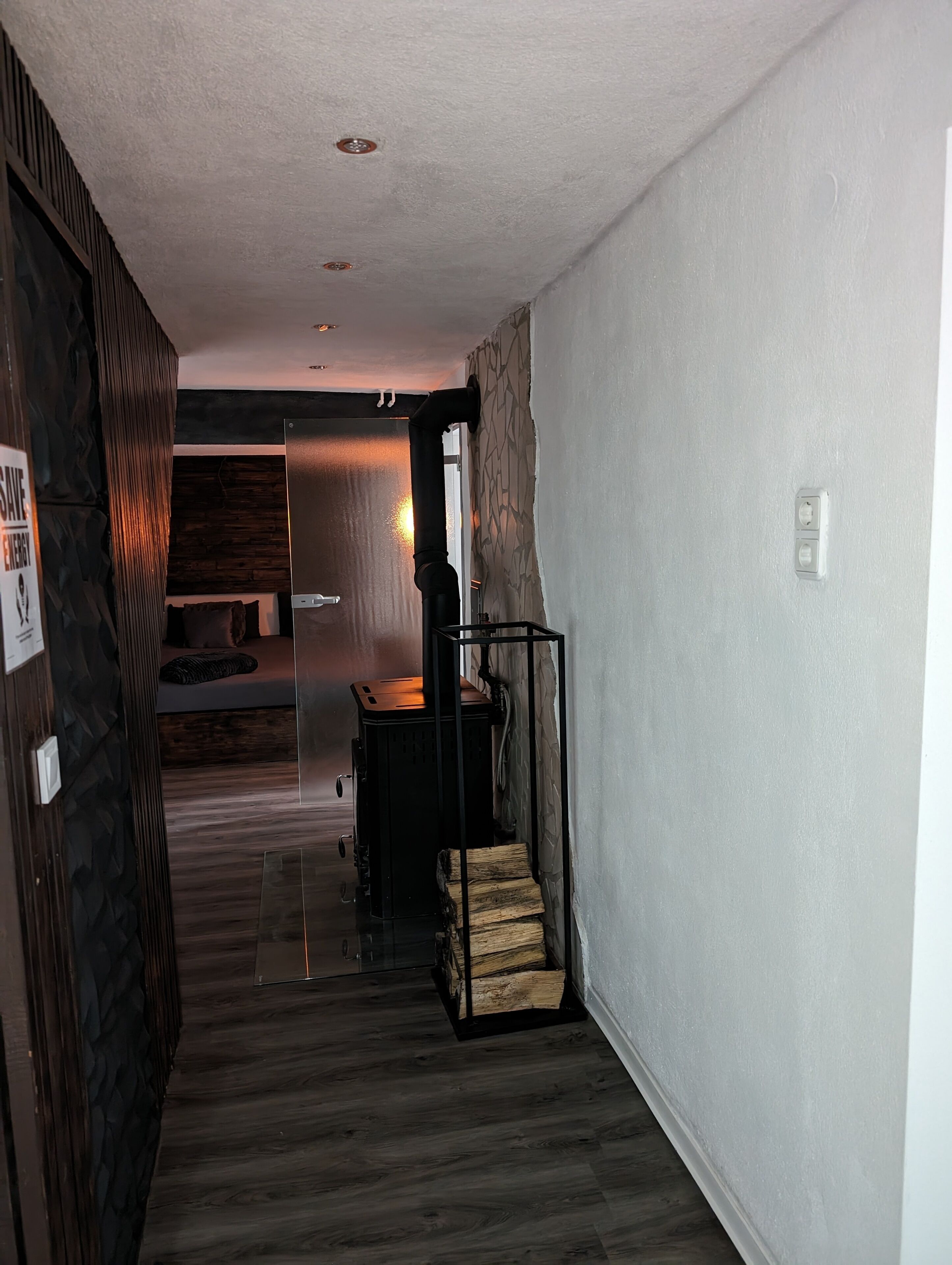 Ein Flur mit einer Treppe, die zu einem Zimmer mit einem Bett und einer Holzwand führt.