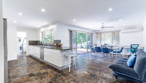 Enjoy a spacious living space with a central kitchen island, dining area, and cozy seating area.