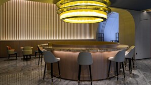 A modern bar area with a circular bar, bar stools, and a unique lighting fixture. - Holiday Inn Express Tianjin Binhai by IHG (Tianjin)
