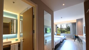 A modern hotel room with a large bed, a desk, a TV, and a bathroom with a sink and mirror. - Holiday Inn Express Tianjin Binhai by IHG (Tianjin)