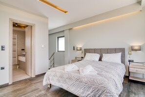 A modern bedroom with a large bed, bedside tables, and a walk-in closet.