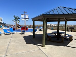 Relax by the pool in a tranquil outdoor space with lounge chairs and a shaded pavilion.