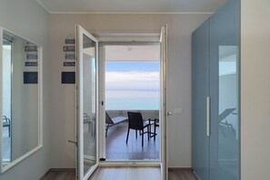 A room with a sliding glass door leading to a balcony with a view of the sea. - WePuglia - Dimora Adriatica (Monopoli)