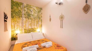 Una habitación de hotel con una cama, un tapiz de árboles y una pared decorada.
