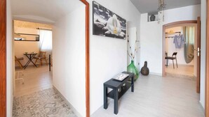 A hallway with a bench, a vase, and a framed picture on the wall. - WePuglia - La Maison-D B&B - Trullo (Cristo Re)