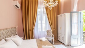 Una habitación de hotel con una cama, una silla, un armario y una araña.