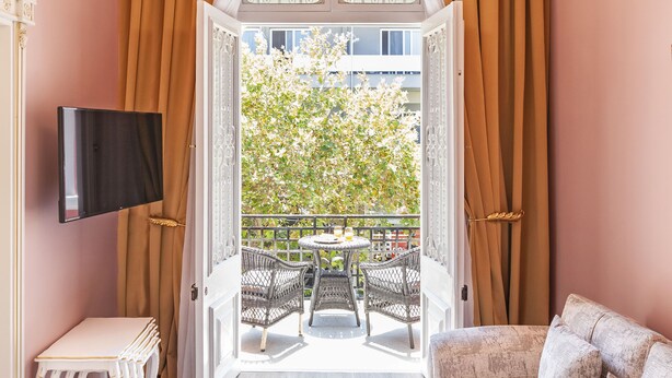 Una habitación con candelabro, sofá, mesa de comedor con comida y televisor en la pared.