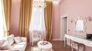 Una habitación con sofá, una silla, una mesa con bandeja, cómoda y espejo.