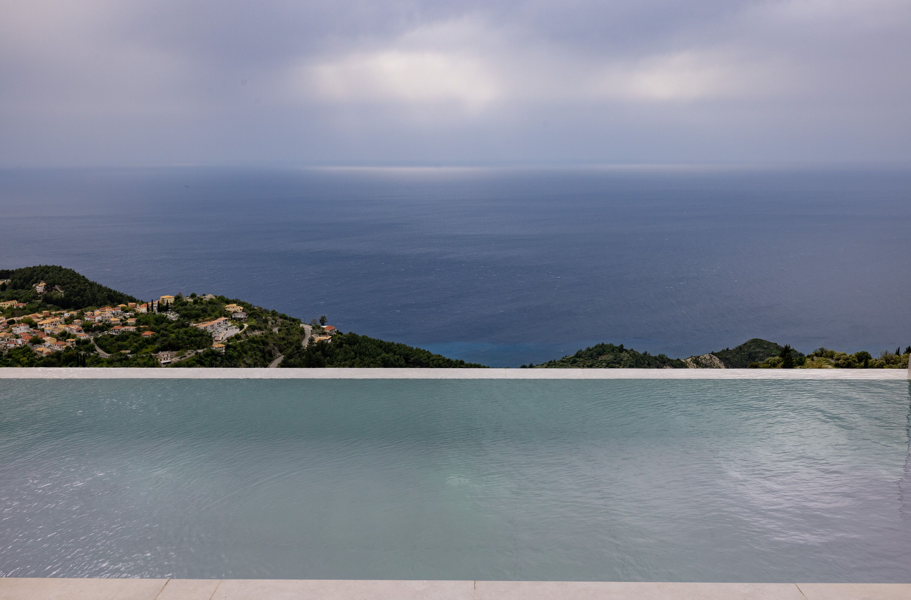 Una piscina al aire libre, sombrillas, sillones reclinables de piscina