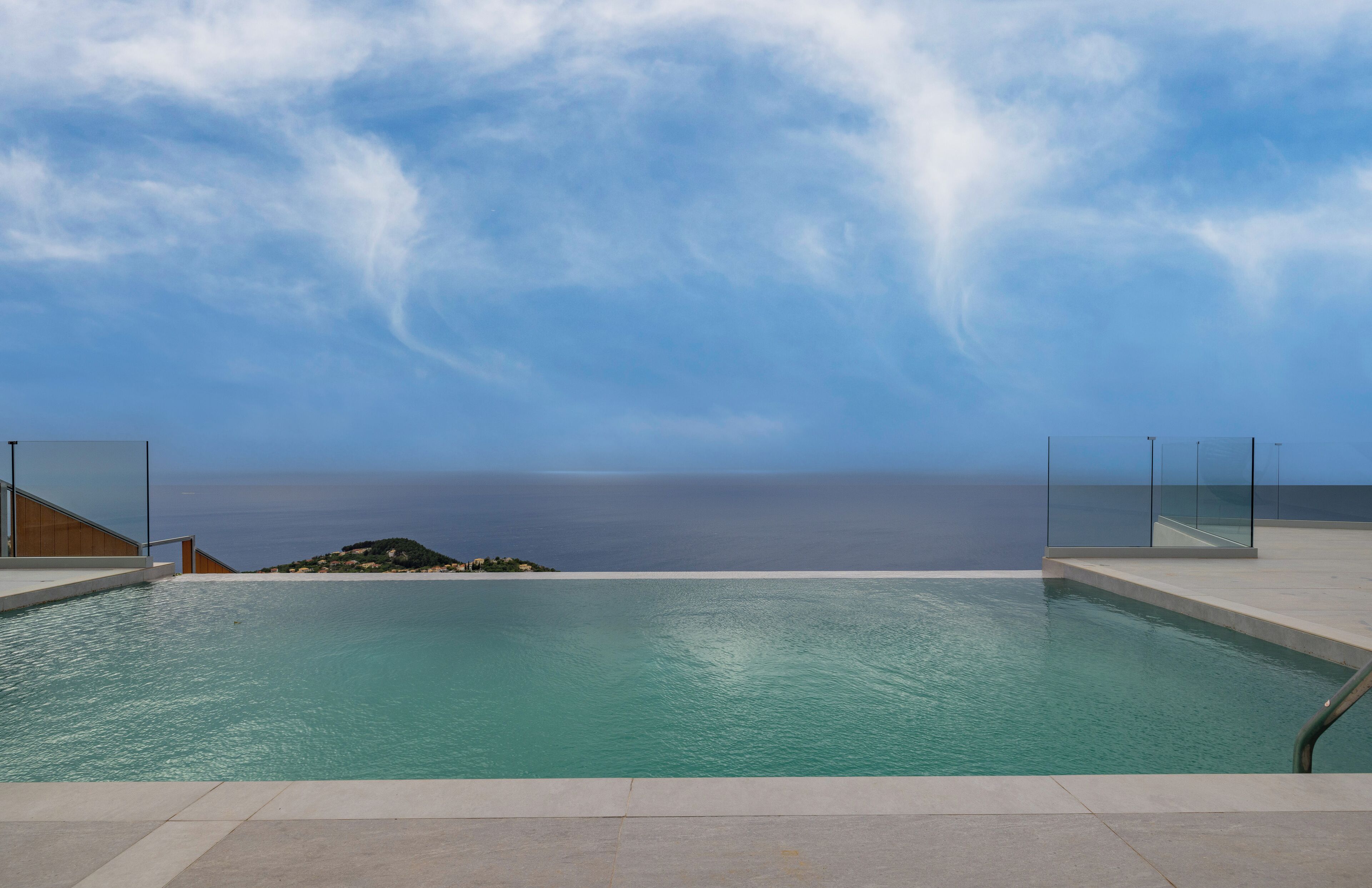 Una piscina con vistas al mar y un cielo despejado.