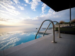 Una piscina con vistas despejadas al océano y al cielo.