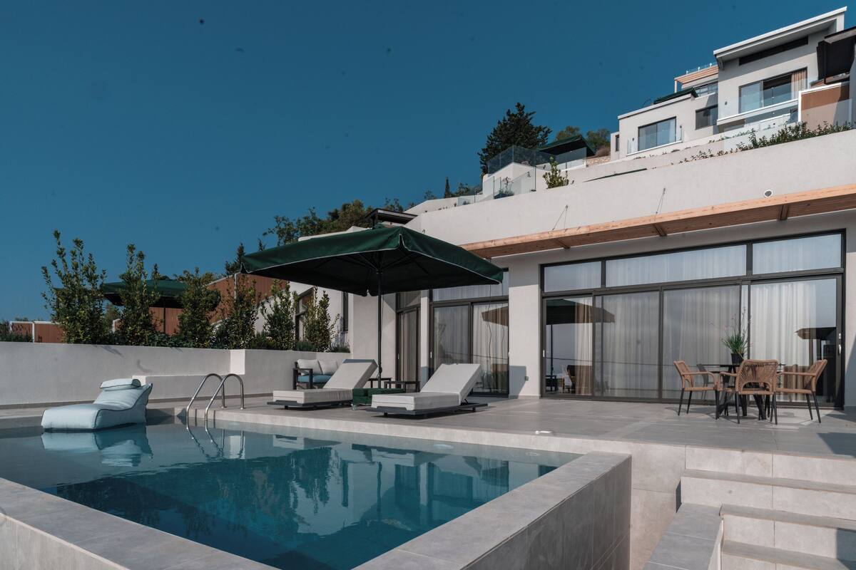 A modern outdoor pool area with lounge chairs, a covered seating area, and a dining table.