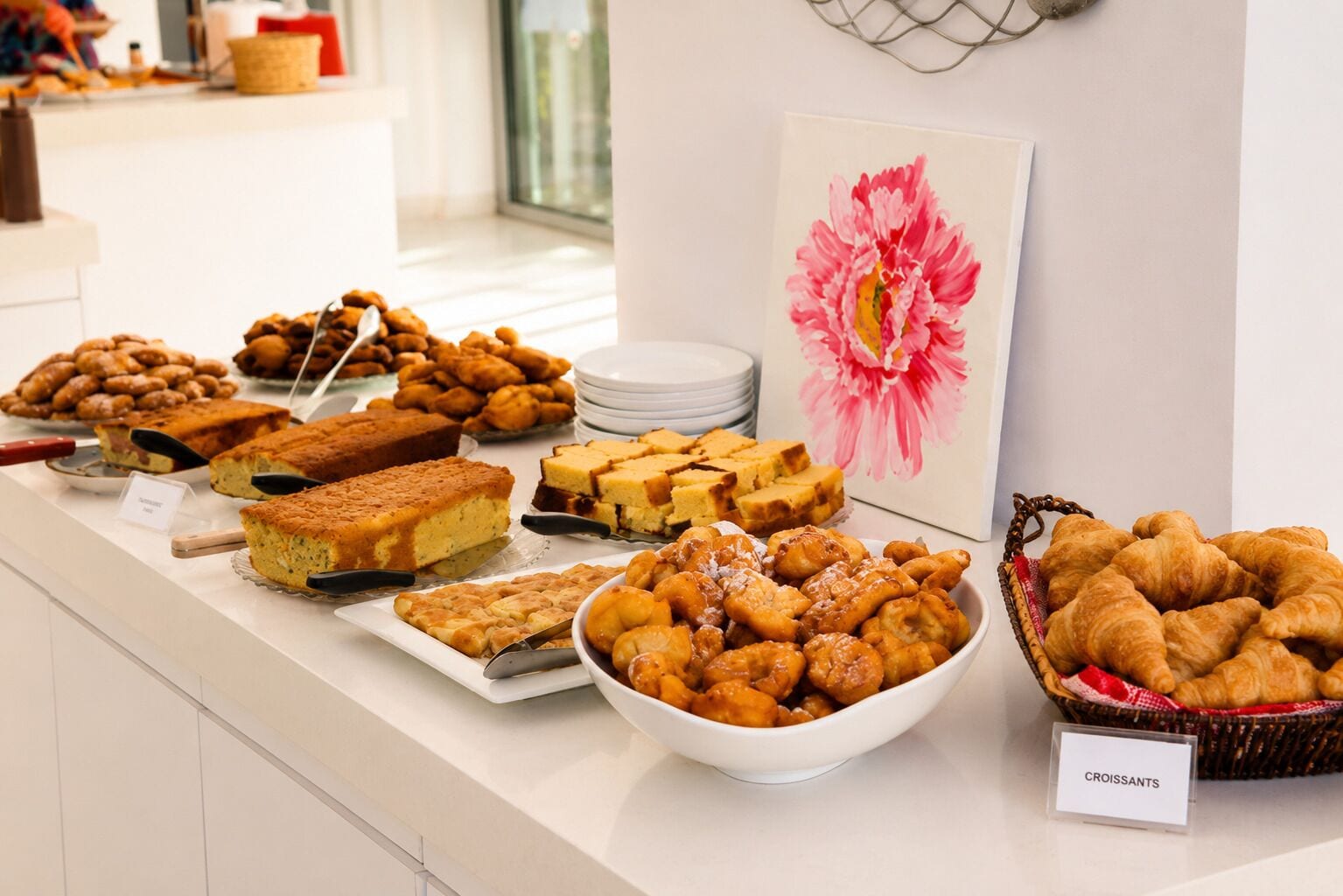 Un bufé con diversas opciones de panadería, incluyendo pasteles, tartas y pan.