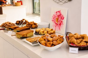 Un bufé con diversas opciones de panadería, incluyendo pasteles, tartas y pan.