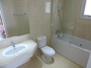 A bathroom with a sink, toilet, and bathtub.
