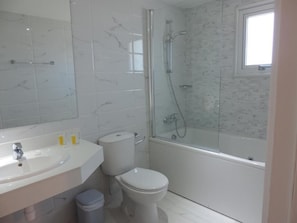 A bathroom with a white sink, toilet, and bathtub.