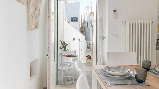 A bright, open-plan living space with a view of a narrow street. - Terrazza Ariafina by Wonderful Italy (Ostuni)