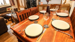 A dining area with a wooden table set for four, surrounded by wooden chairs. - Rake Hey Farm (Todmorden)