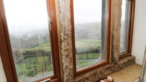 A room with three windows, each with a wooden frame and stone ledge. - Rake Hey Farm (Todmorden)