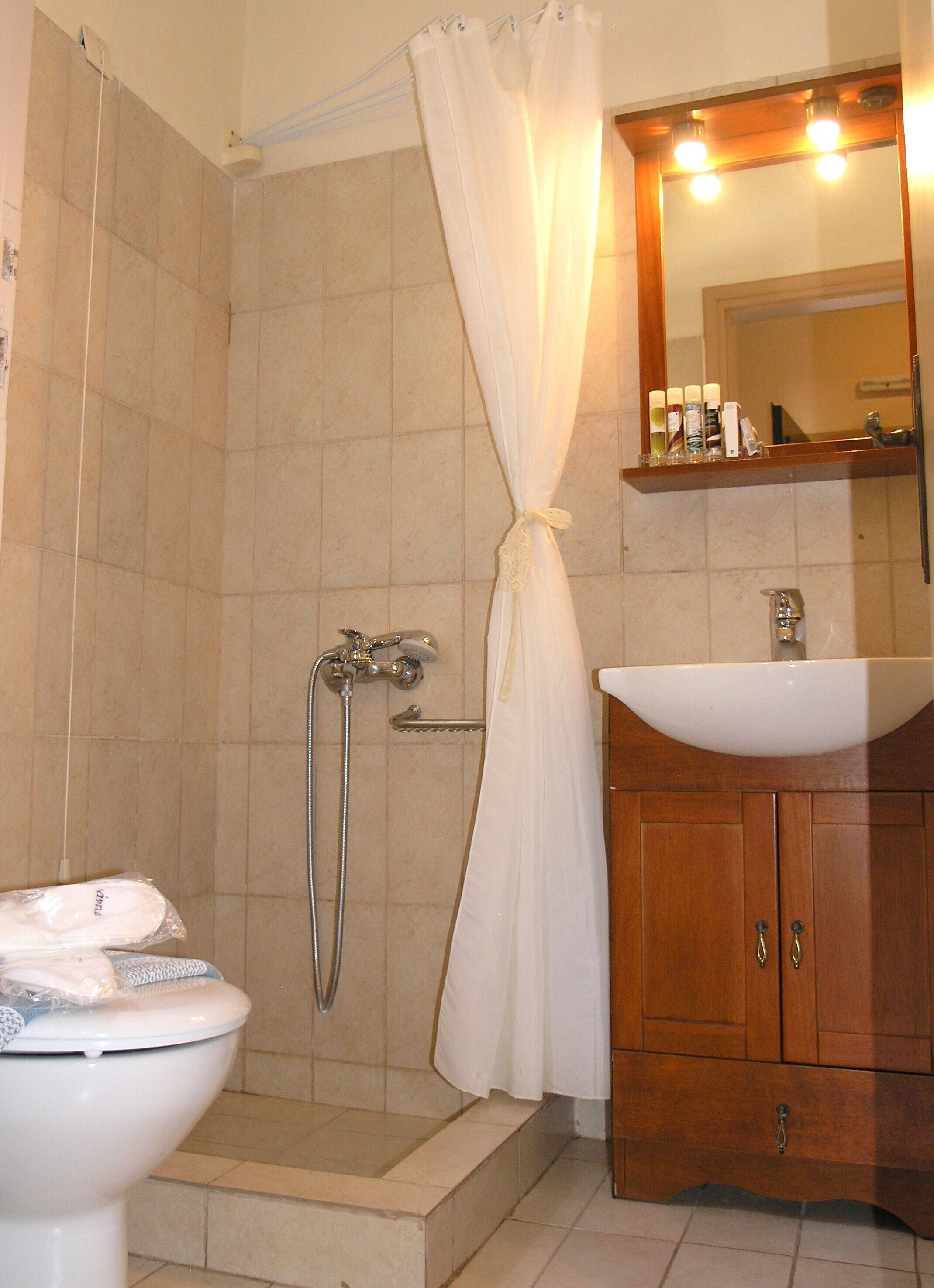 A bathroom with a shower, toilet, and sink.