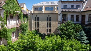 Un bâtiment doté d’une cour intérieure, elle-même entourée d’une végétation luxuriante.