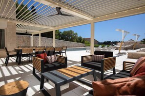 An outdoor patio with modern furniture, a pool, and a view of the landscape.