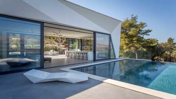 A modern house with a swimming pool, large glass windows, and an outdoor dining area. - Villa Masterpiece - high end luxury vill with 5 bedrooms on island Korčula by MyWaycation (Grad Korcula)