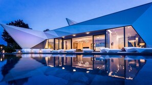 A modern building with a pool and lounge area.