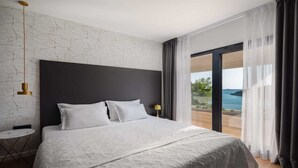 A modern bedroom with a large bed, a view of the sea, and a minimalist design. - Villa Endless Summer - 5 Star beachfront villa with a pool by MyWaycation (Vinišće)