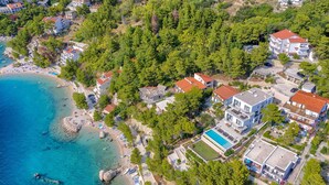 An aerial view of a coastal area with a beach, several buildings, and a swimming pool. - Villa Platinum - outstanding beachfront villa with 9 bedrooms by MyWaycation (Brela)