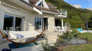 Une maison avec un balcon, un hamac et un espace piscine.