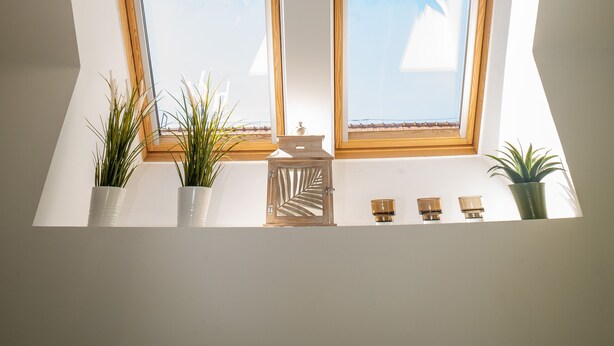 A skylight with four windows, each with a wooden frame, allowing natural light into a room. - Palms Apartments Budapest (Budapest)