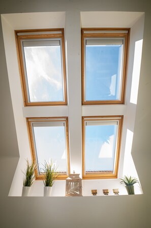 Ein Oberlicht mit vier Fenstern, jeweils mit Holzrahmen, lässt natürliches Licht in einen Raum.