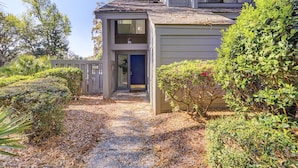 A two-story building with a covered porch and a small entrance door.