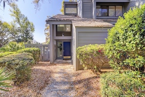 A two-story building with a covered porch and a small entrance door.