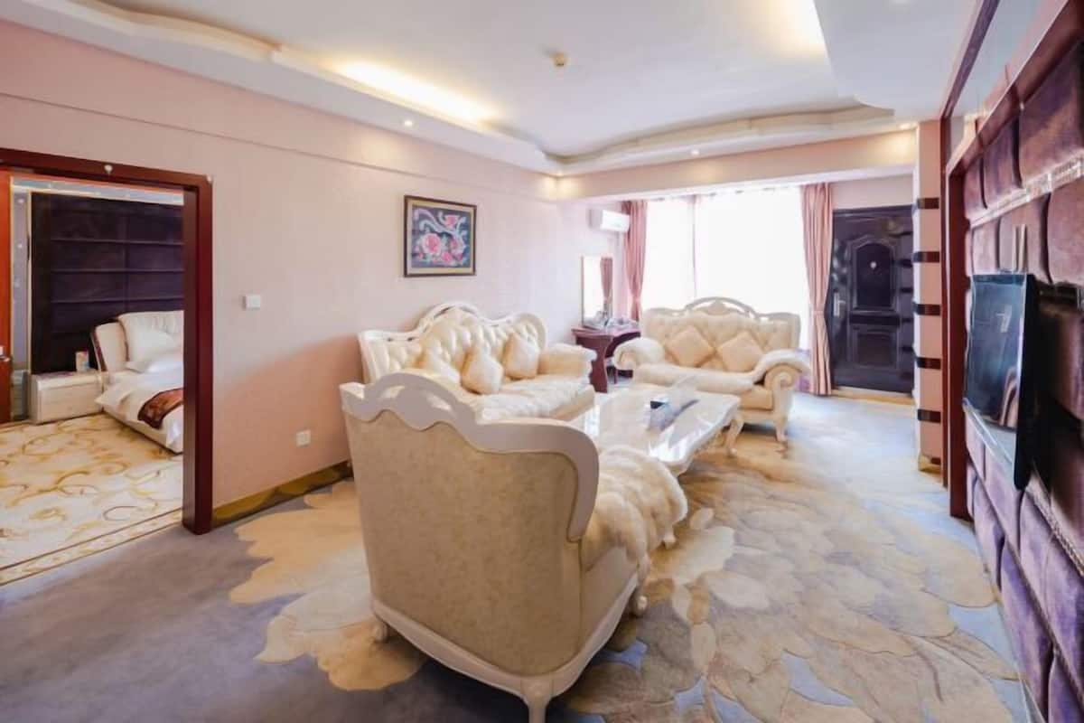 Ein geräumiges Wohnzimmer mit einer großen Couchgarnitur, einem Couchtisch und einem Fernseher.