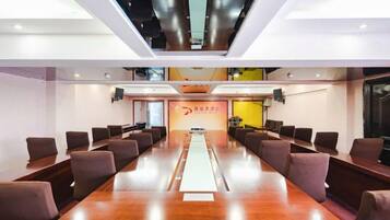 A conference room with a long table, chairs, and a banner with text.