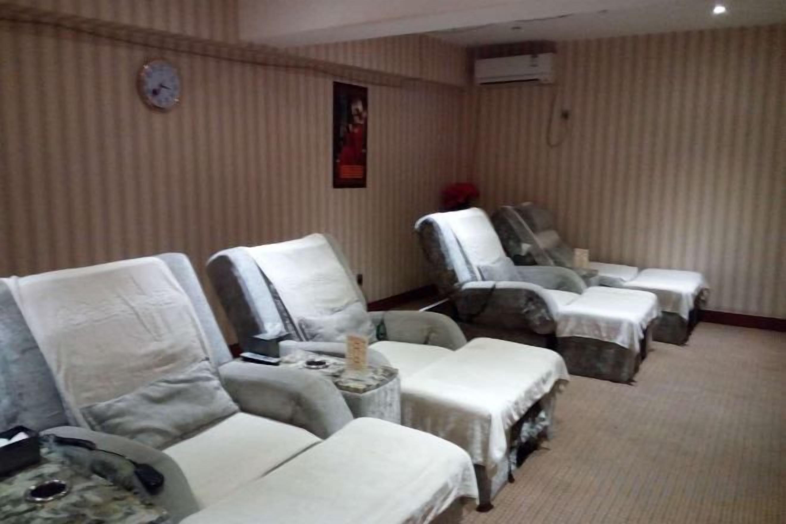 A room with four reclining chairs, each with a table in front.