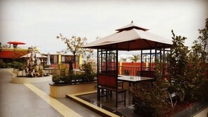 An outdoor seating area with a gazebo, tables, and planters.