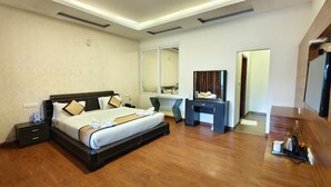 Une chambre d’hôtel avec un grand lit, un bureau, un miroir et une télévision.