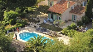 A villa with a swimming pool, outdoor seating, and lush greenery. - Villa for 10 • Pool • 5 Suites • Grimaud (Grimaud)