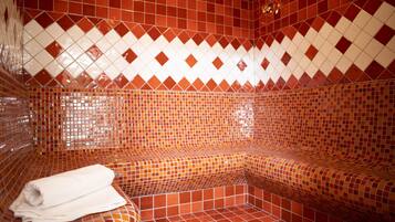 Une salle de bain carrelée avec un banc et une serviette.