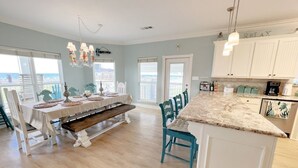 A spacious kitchen with a large island, white cabinetry, and a view to the outside.